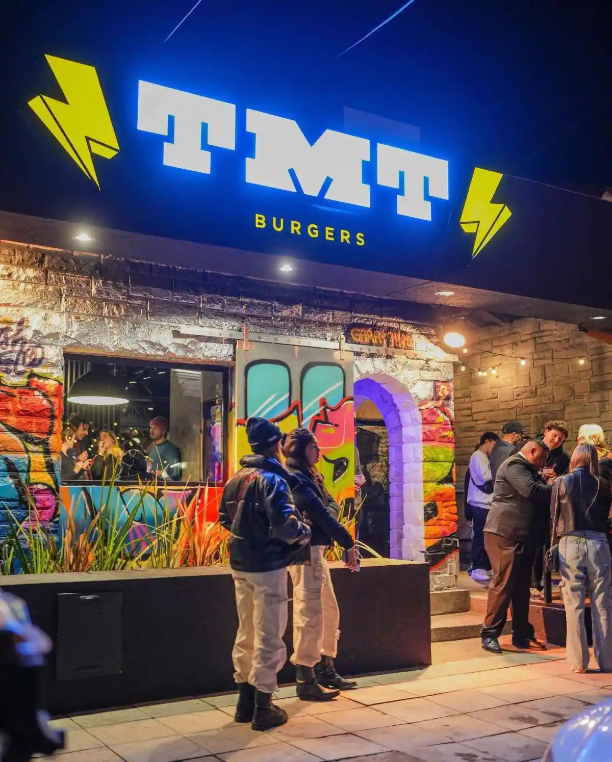 El cartel luminoso de TMT Burgers la noche de la inauguración en Garay, junio 2023